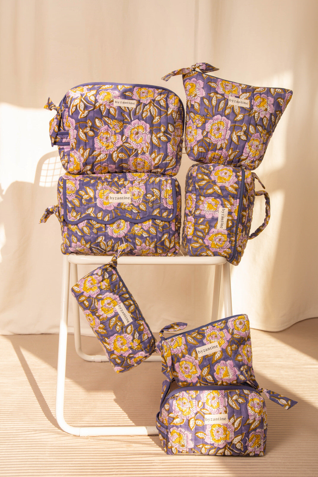 Collection de trousses N°113 Bleu de Byzantine, fleurs jaunes sur fond bleu, sur une chaise blanche
