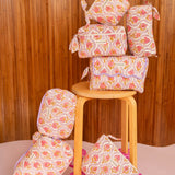 Collection de trousses Éphèse Rose de Byzantine, fleurs rose et orangé, sur un tabouret