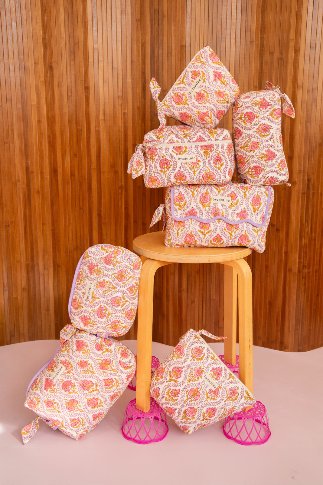 Collection de trousses Éphèse Rose de Byzantine, fleurs rose et orangé, sur un tabouret