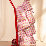 Collection de trousses Flora Lilas de Byzantine, rayures fleuries rose et violet, sur un diable rouge