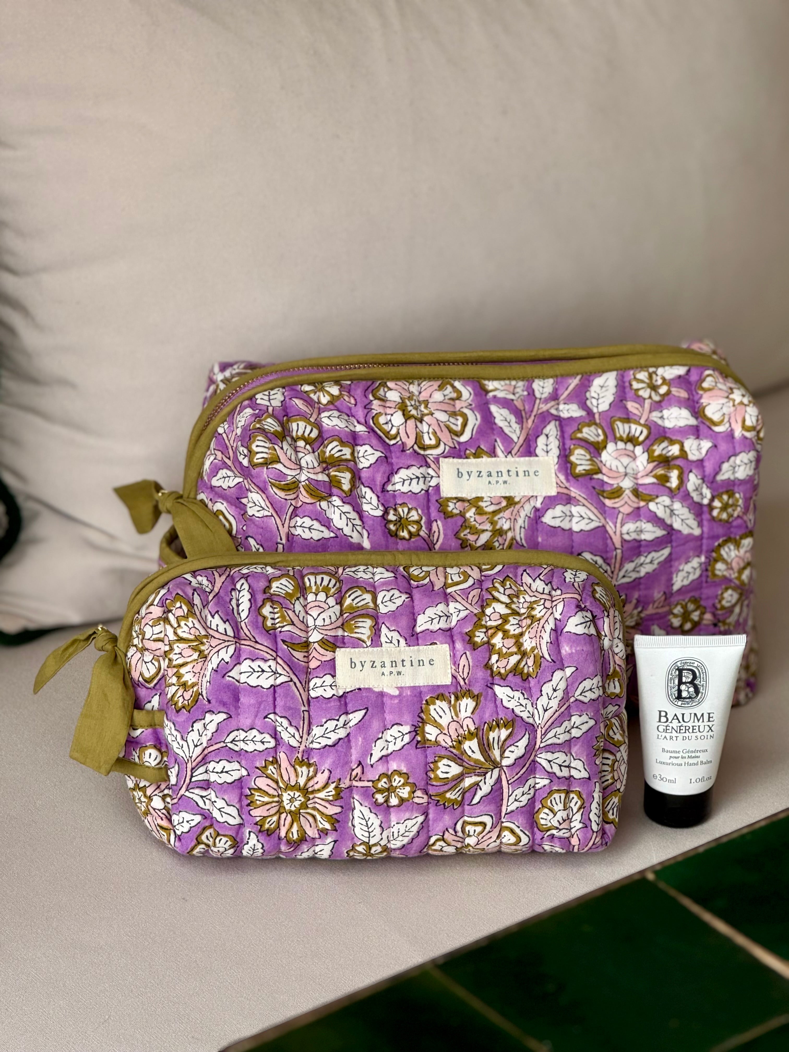 Duo de trousses de toilette Carthage Lilas posées sur un banc, avec un soin pour le visage