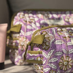 Gros plan sur la trousse de toilette Carthage Lilas, matelassage et poignée olive