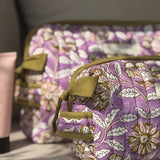Gros plan sur la trousse de toilette Carthage Lilas, matelassage et poignée olive