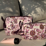 Duo de trousses de toilette Carthage Prune de byzantine, fleuri prune et rose, sur un banc
