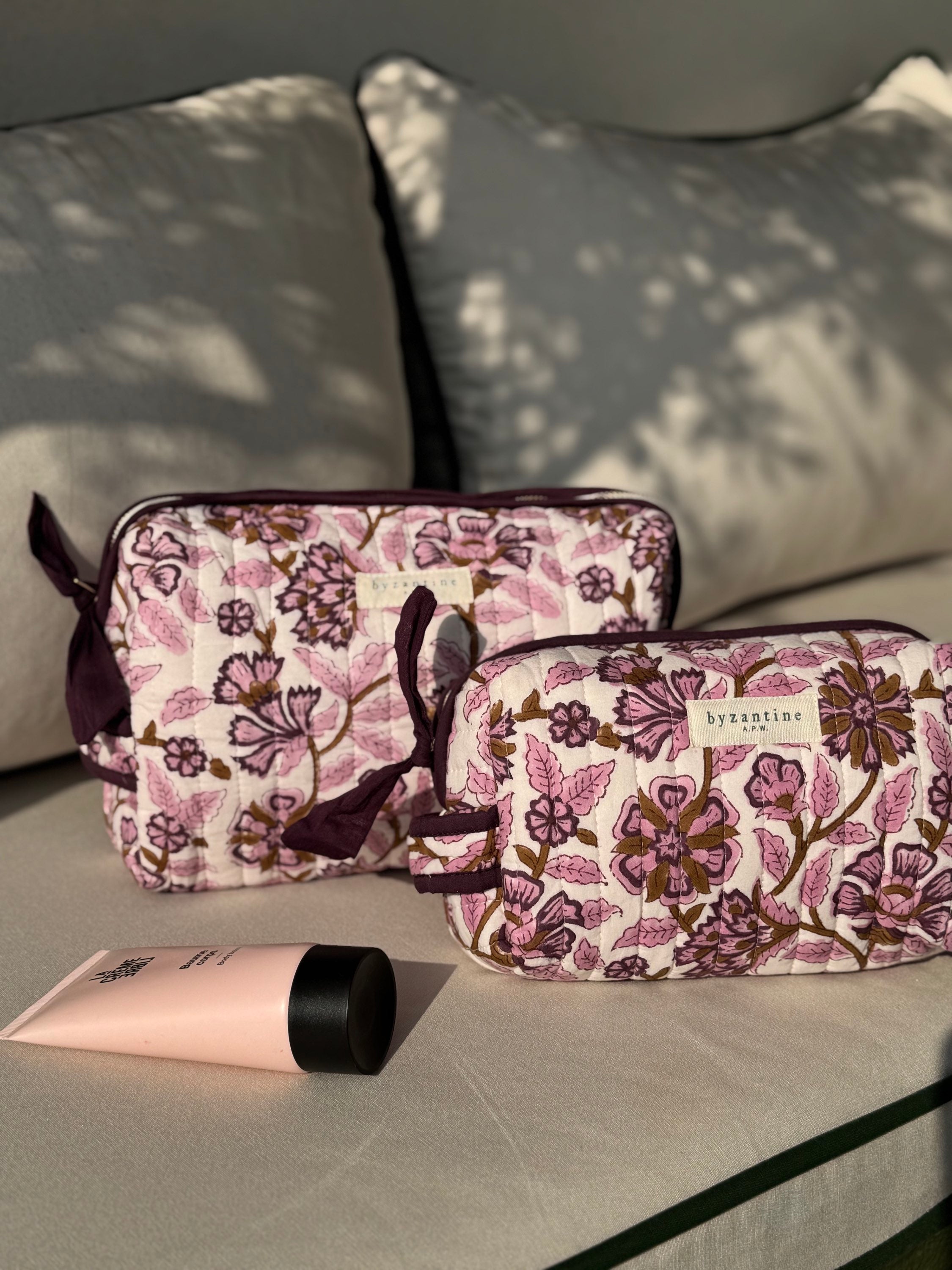 Duo de trousses de toilette Carthage Prune de byzantine, fleuri prune et rose, sur un banc