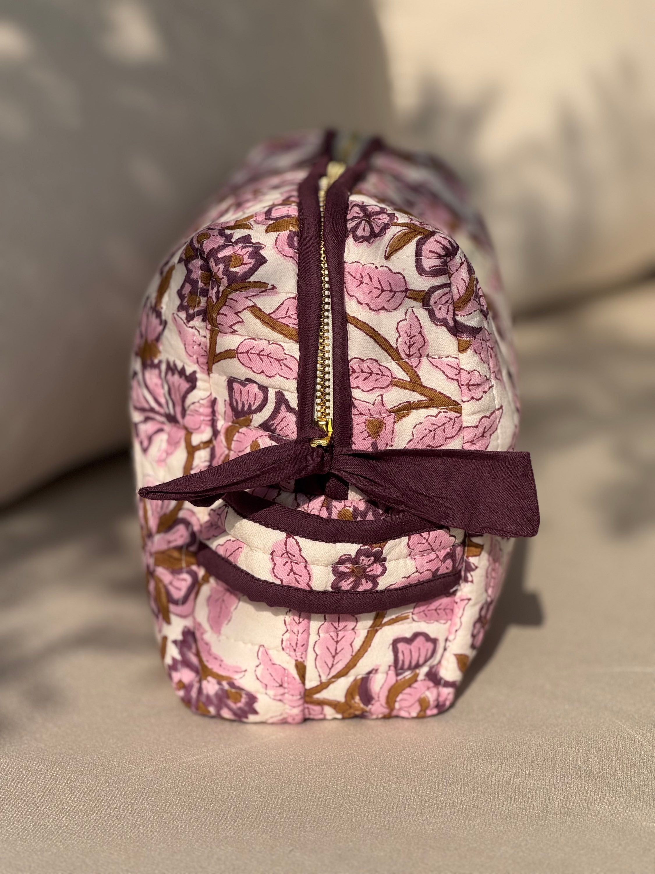 Grande trousse de toilette Carthage Prune vue de profil, matelassée à fleurs prune