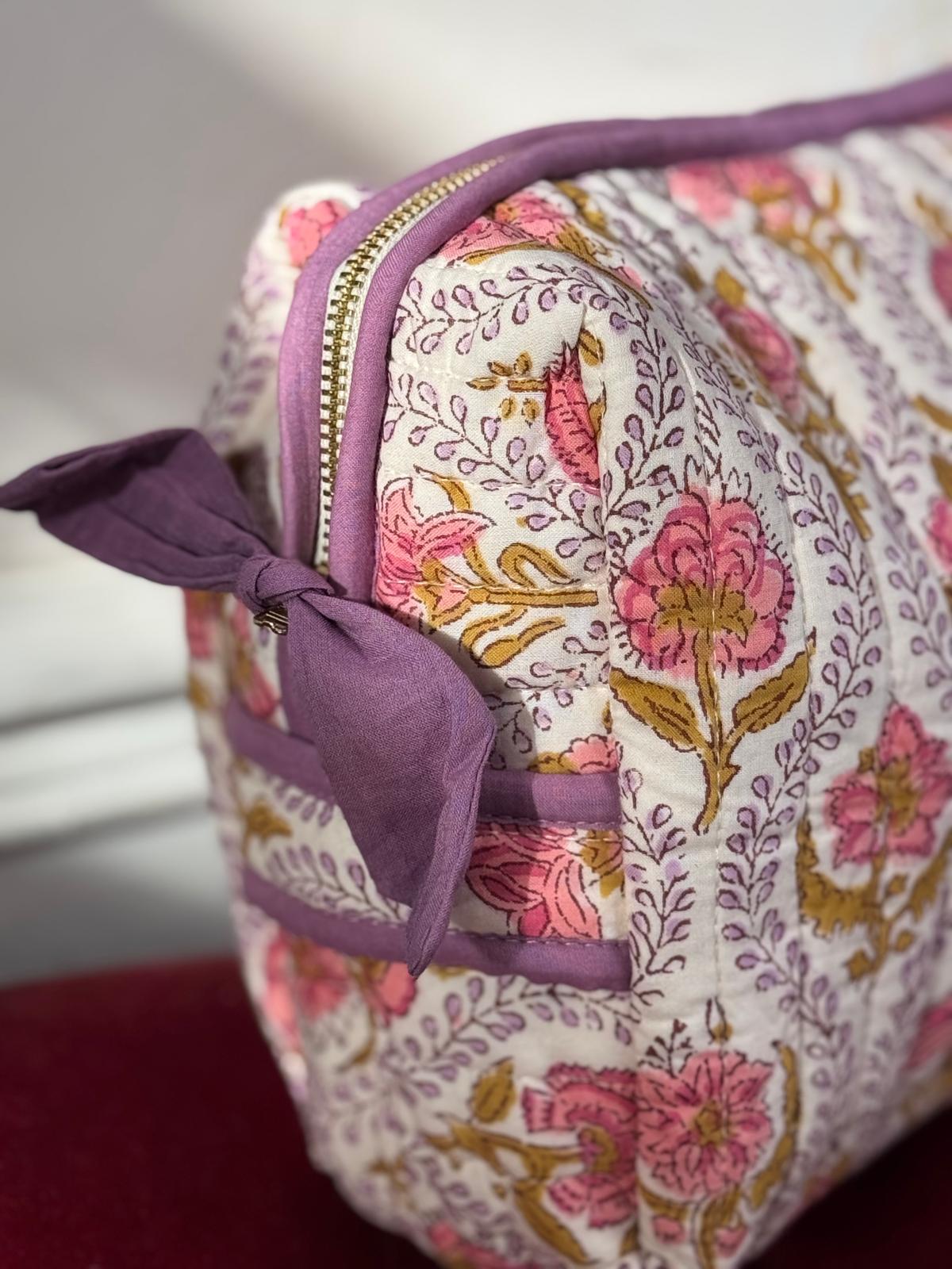 Gros plan sur la trousse de toilette Éphèse Rose de byzantine, fleurs roses et nœud lilas