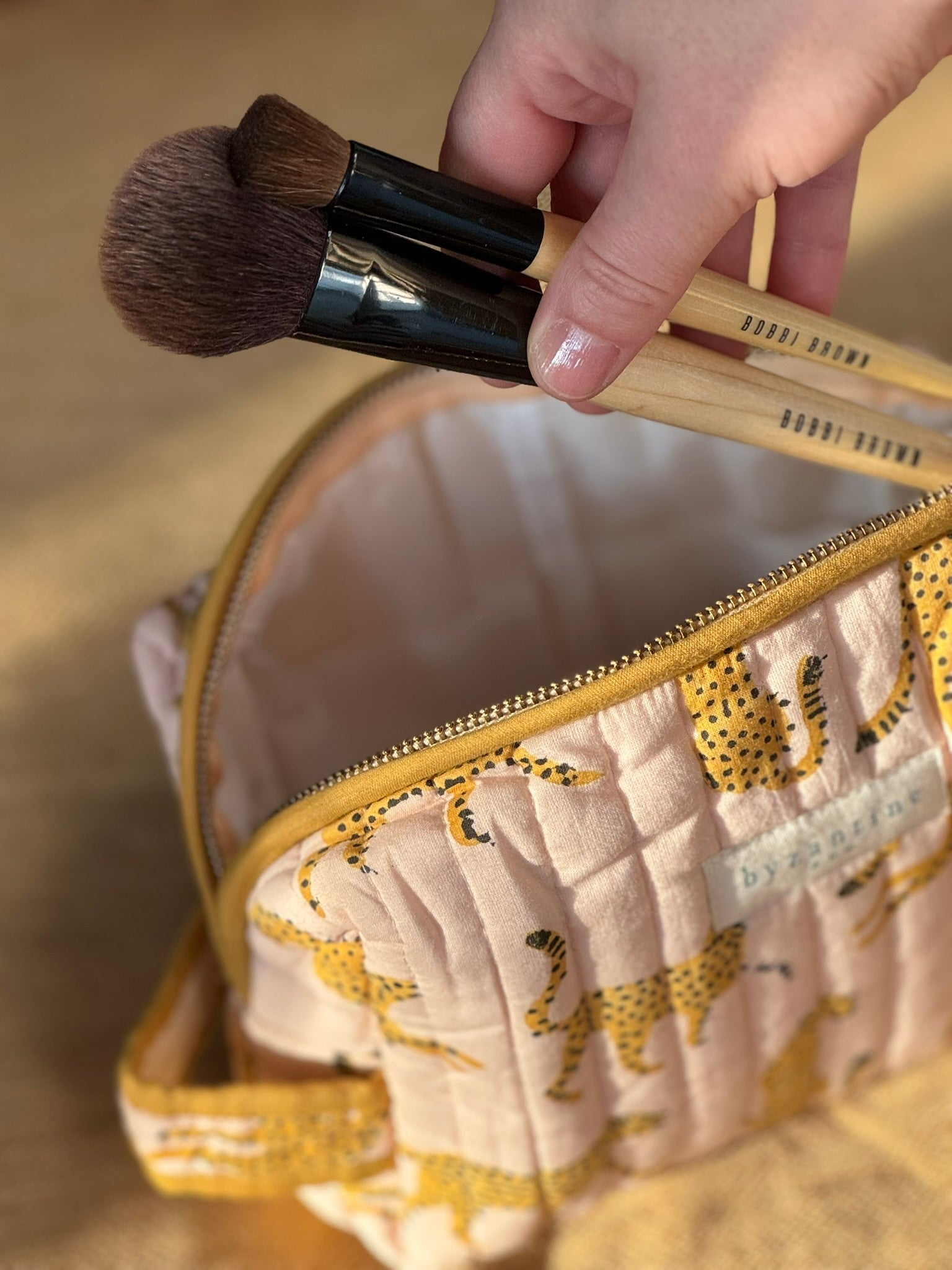 Petite trousse de toilette Fauve Rose ouverte, avec des pinceaux de maquillage