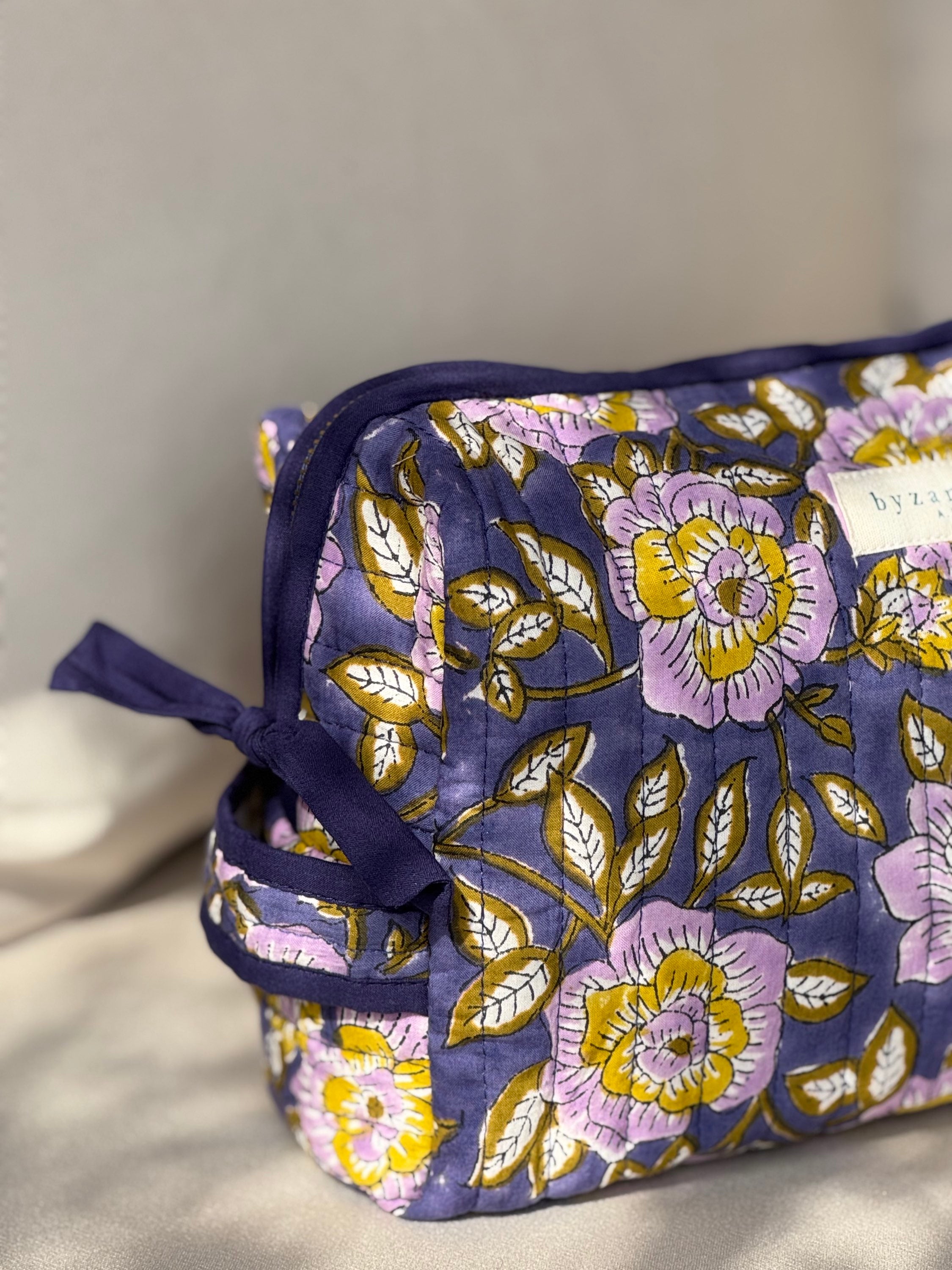 Gros plan sur la trousse de toilette N°113 Bleu, imprimé fleuri lilas et jaune