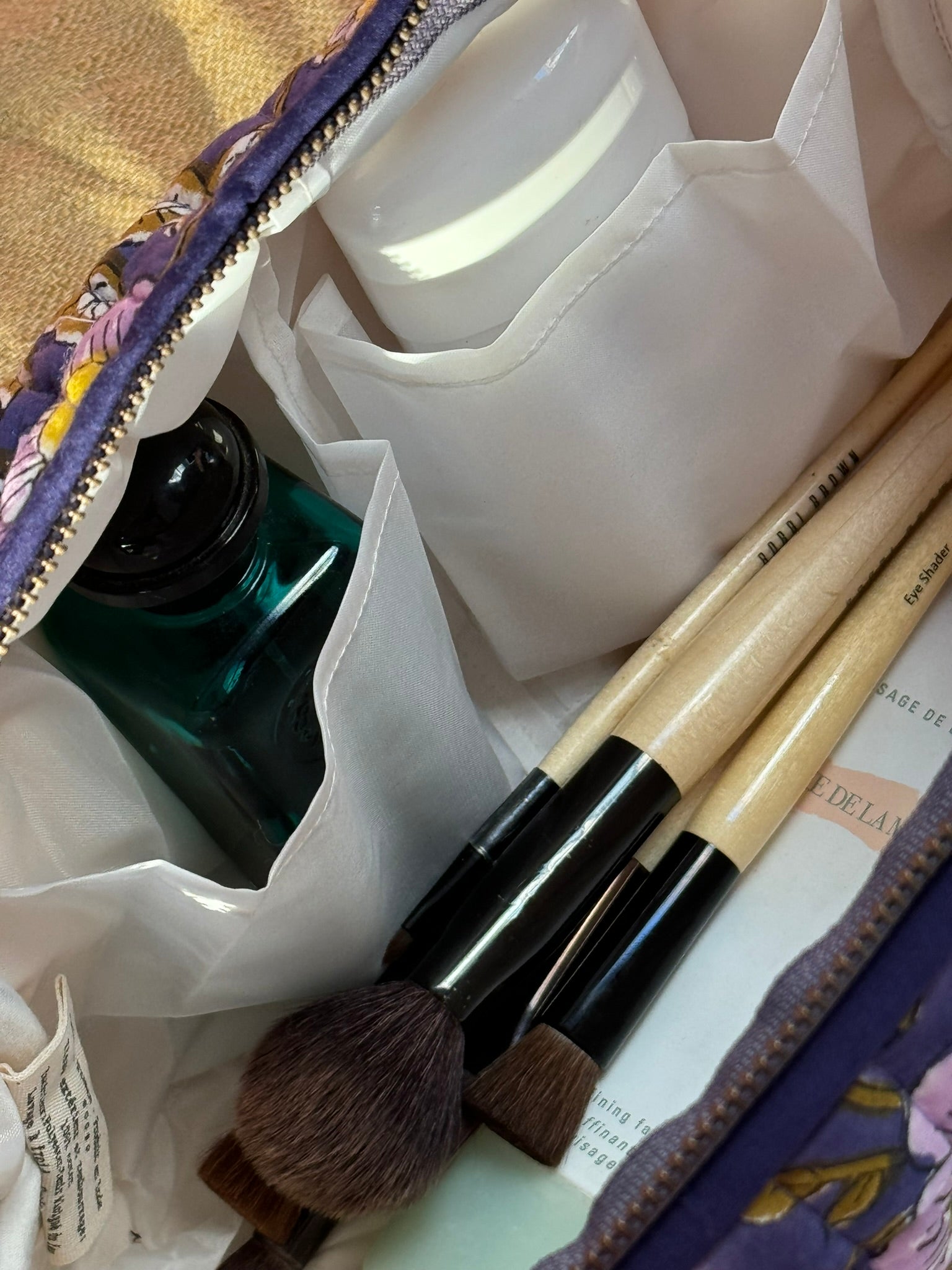 Gros plan sur l'intérieur de la trousse de toilette N°113 Bleu, avec pinceaux et flacons