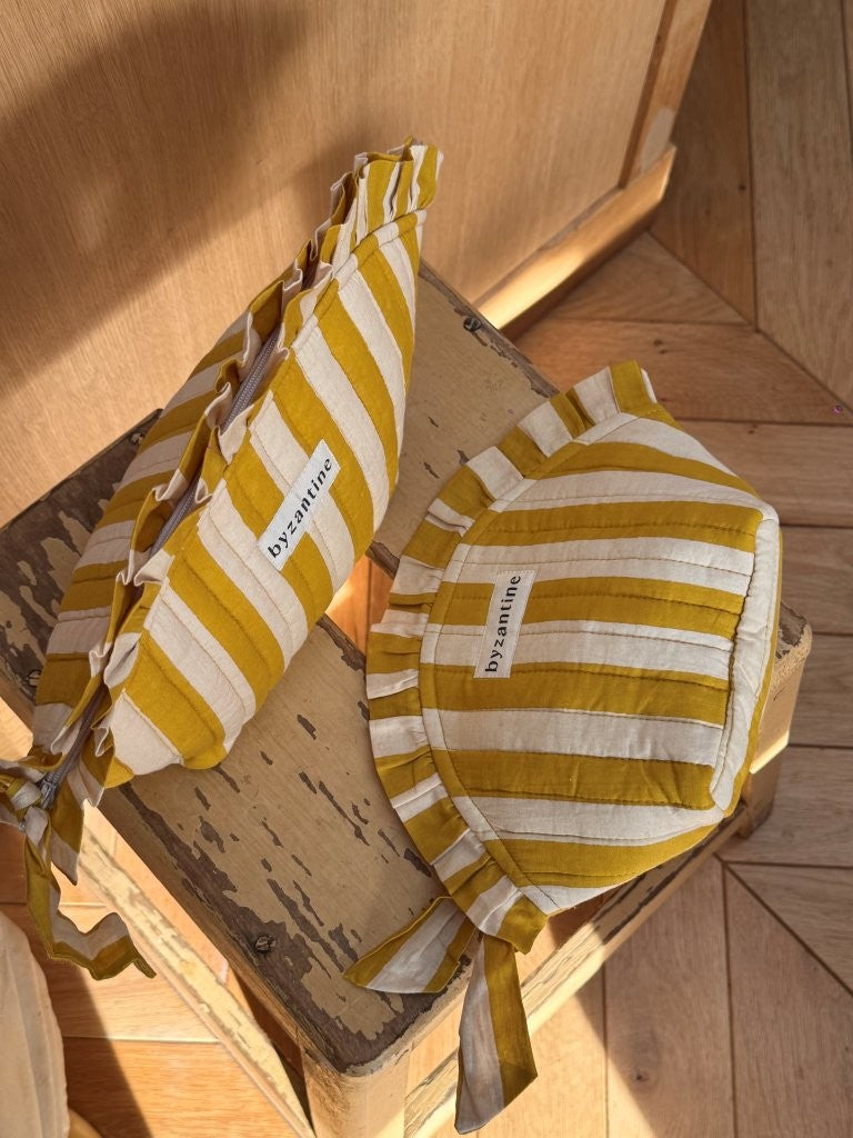 Grande et petite trousses froufrou Pacha Passion posées sur un tabouret, vues de dessus