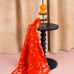 Foulard Antonia Tomato drapé sur un guéridon bleu marine