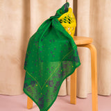 Foulard Antonia Vert noué sur un tabouret, avec un filet jaune