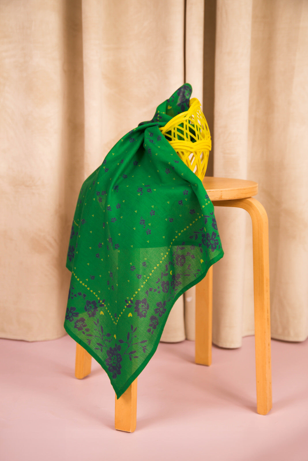 Foulard Antonia Vert noué sur un tabouret, avec un filet jaune