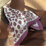 Grand foulard Léopard Écru et Violet drapé sur un tabouret