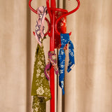 Foulards Byzantine en coton imprimé suspendus à un porte-manteau rouge
