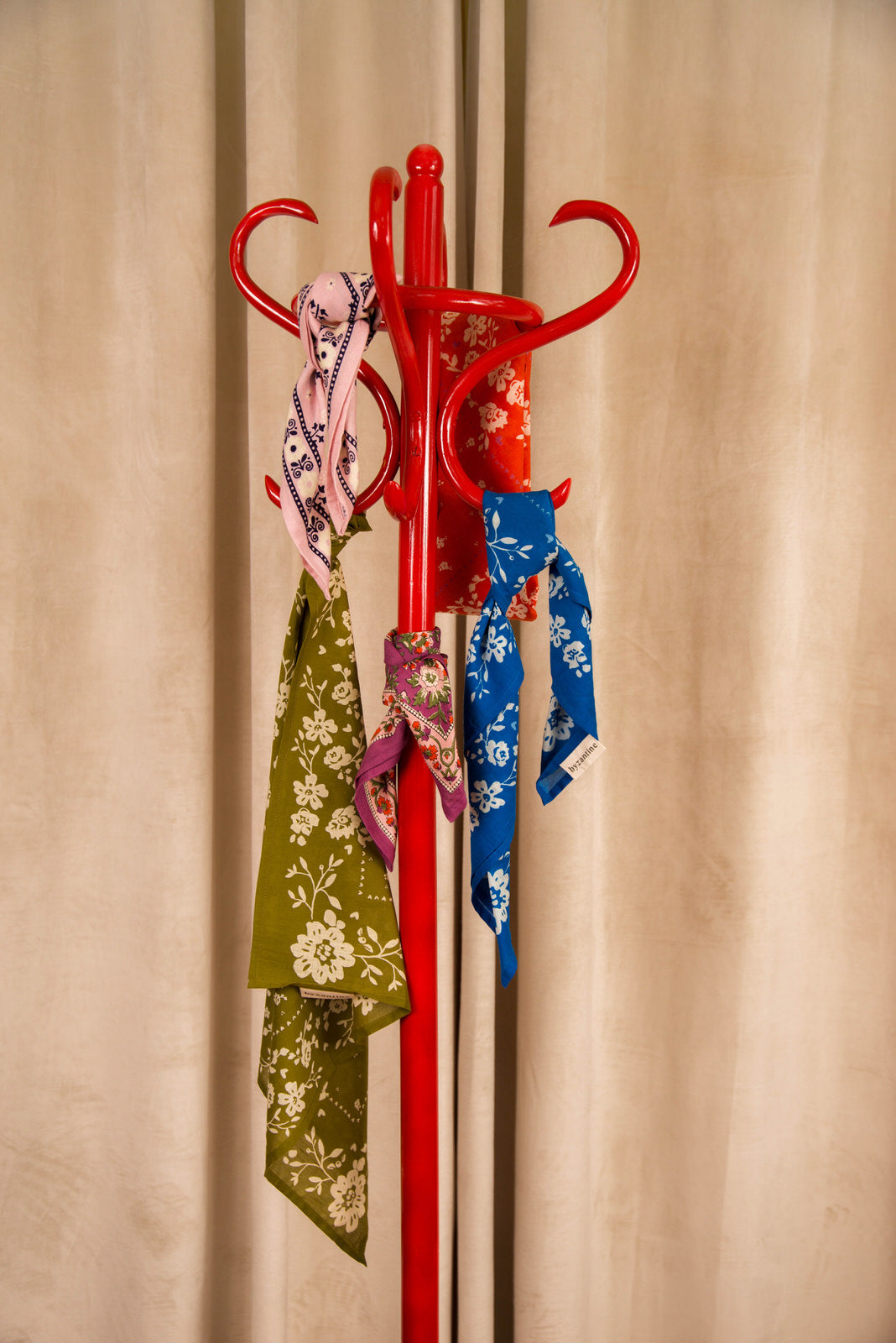 Foulards Byzantine en coton imprimé suspendus à un porte-manteau rouge