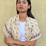 foulard écru imprimé petites fleurs sur les épaules d'une jeune femme