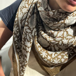 Gros plan sur le grand foulard Antioche Kaki porté au cou