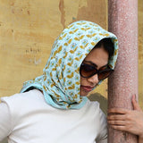 Grand foulard César Bay porté en fichu sur la tête avec des lunettes de soleil