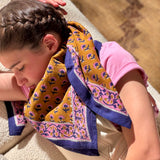 Grand foulard Séléné Fauve porté en châle, petits bouquets roses et bleus sur fond fauve
