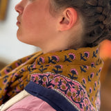 Grand foulard Séléné Fauve noué au cou, bordure fleurie rose et bleu roi, vue de profil
