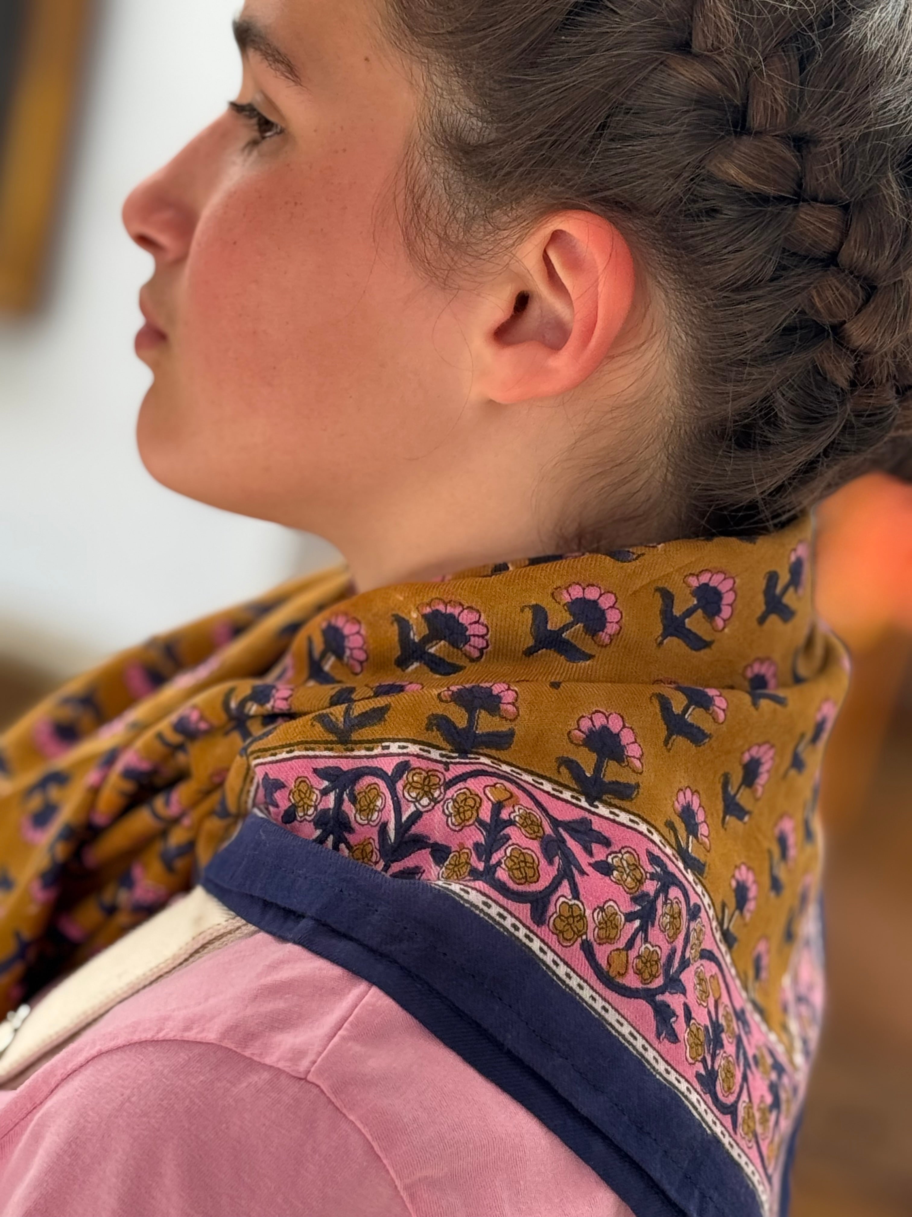 Grand foulard Séléné Fauve noué au cou, bordure fleurie rose et bleu roi, vue de profil