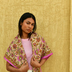 Grand foulard Théodora Rose porté sur les épaules, tee-shirt rose