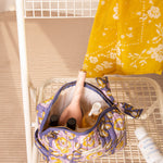 Grande trousse beauté N°113 Bleu ouverte sur une chaise blanche, remplie de soins