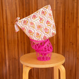 Grande trousse beauté Éphèse Rose posée sur une corbeille rose, sur un tabouret