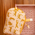 Gros plan sur la grande trousse beauté Fauve Rose, guépards ocre et nœud