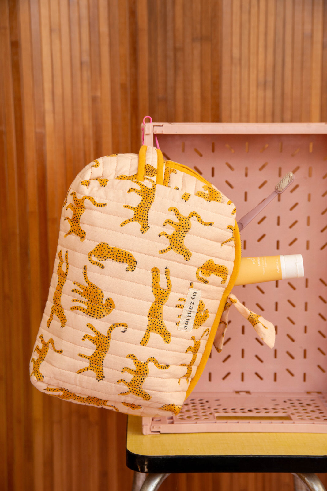 Gros plan sur la grande trousse beauté Fauve Rose, guépards ocre et nœud