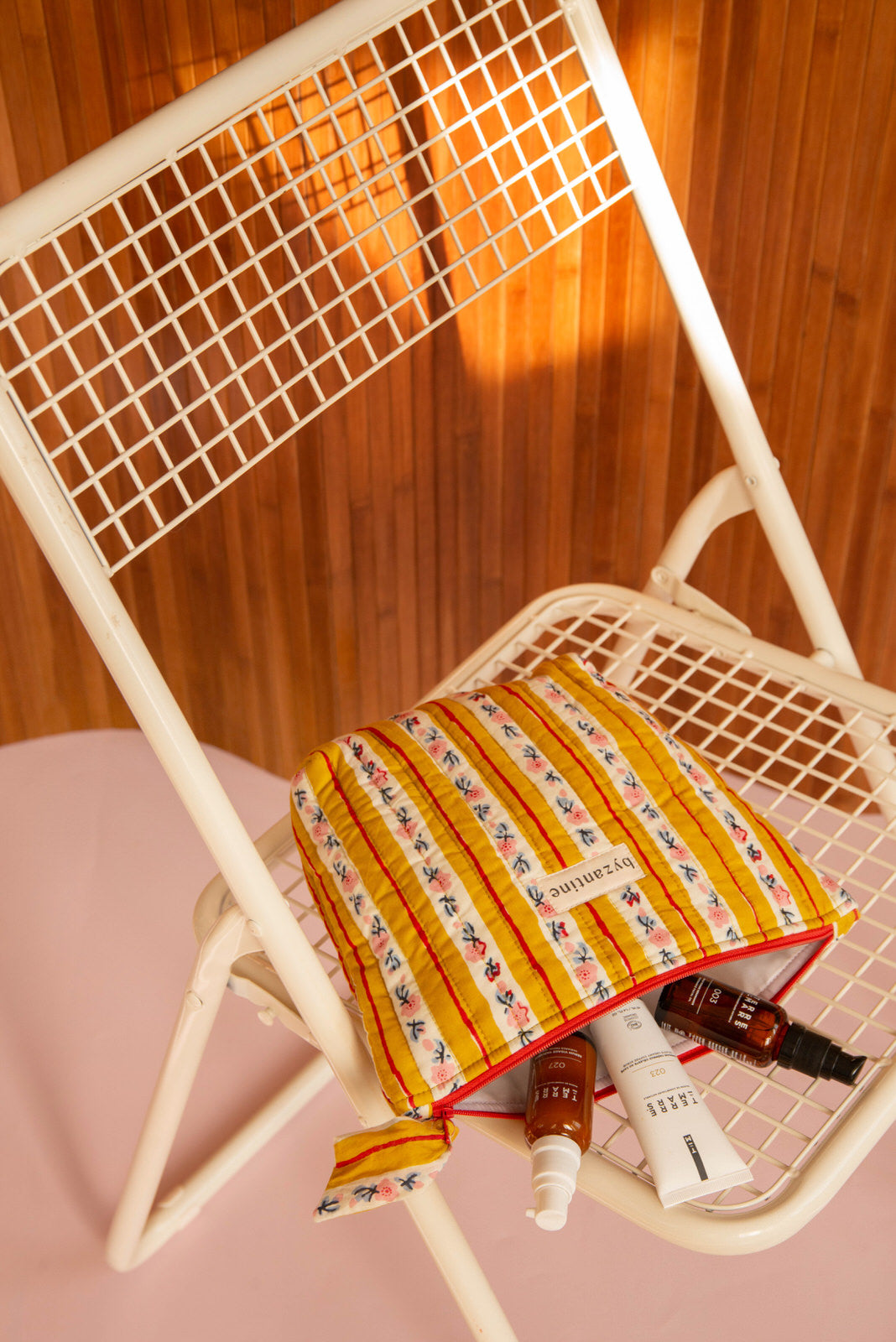 Grande trousse beauté Flora Passion ouverte sur une chaise pliante, soins à l'intérieur