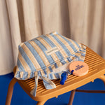 Grande trousse froufrou Pacha Bleu ciel posée sur un escabeau en bois, avec un miroir