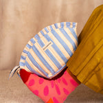 Grande trousse froufrou Pacha Bleu ciel posée sur une jambe en chaussette rose à pois