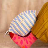 Grande trousse froufrou Pacha Bleu ciel posée sur une jambe en chaussette rose à pois