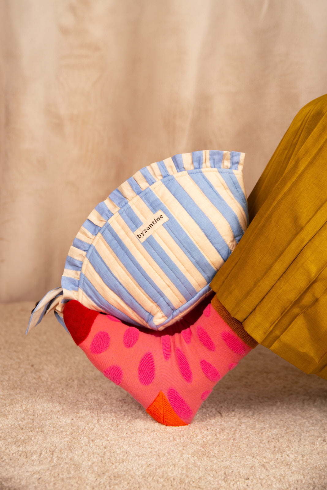 Grande trousse froufrou Pacha Bleu ciel posée sur une jambe en chaussette rose à pois