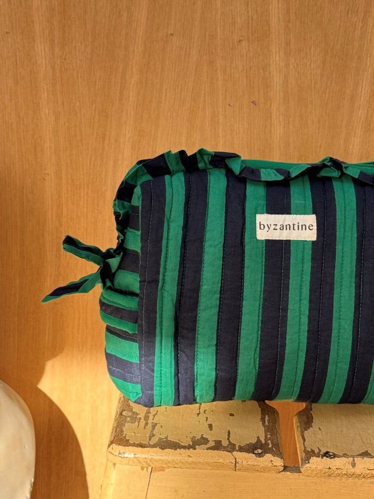 Grande trousse à volants Pacha Menthe posée sur un tabouret en bois