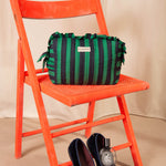 Grande trousse volants Pacha Menthe sur une chaise orange, mocassins en velours au sol