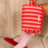Grande trousse volants Pacha Tomato tenue à la main, ballerines rouges en velours