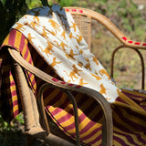 Nappe indienne Fauve Écru drapée sur un fauteuil en rotin dans un jardin