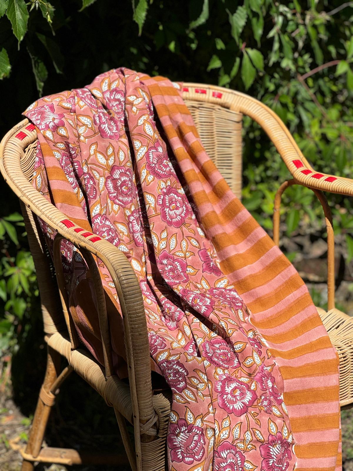Nappe N°113 Vieux rose drapée sur un fauteuil en rotin dans un jardin
