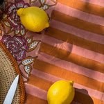 Citrons posés sur la bordure rayée de la nappe N°113 Vieux rose