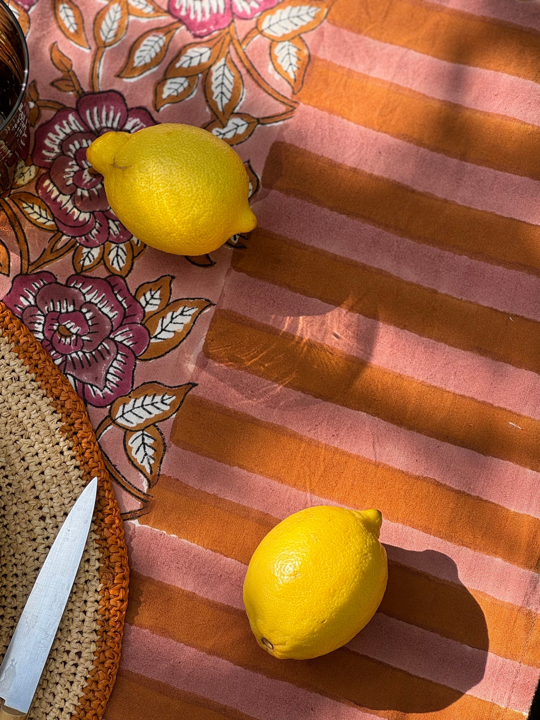 Citrons posés sur la bordure rayée de la nappe N°113 Vieux rose