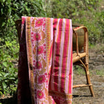 Nappe rayée Camélia Rose drapée sur une chaise dans un jardin