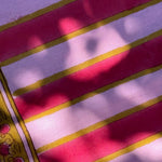 Gros plan sur les rayures roses et lilas de la nappe Camélia Rose