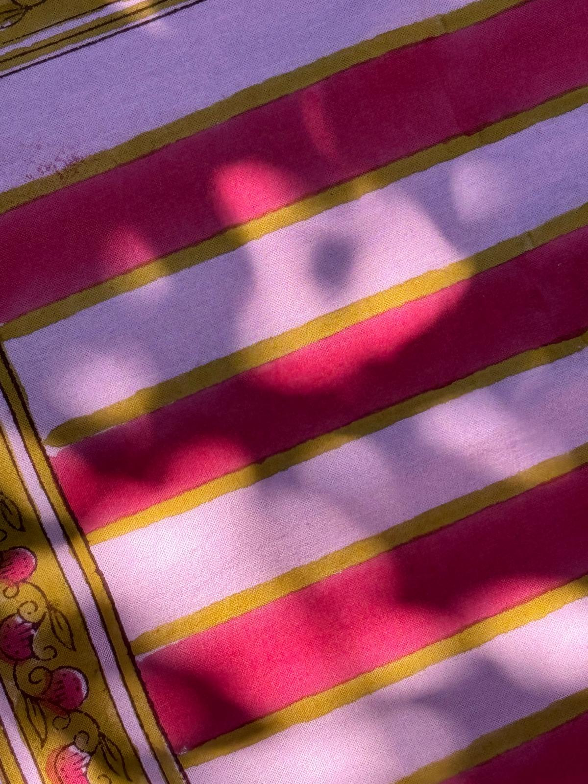 Gros plan sur les rayures roses et lilas de la nappe Camélia Rose
