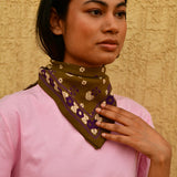 Petit foulard Anastase Olive porté au cou, main posée sur le foulard