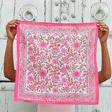 Petit foulard Andromaque Rose de byzantine déplié, tenu devant une porte blanche