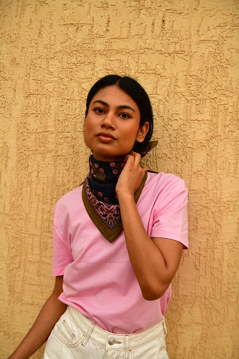 Petit foulard Antigone Nuit noué au cou, porté avec un tee-shirt rose